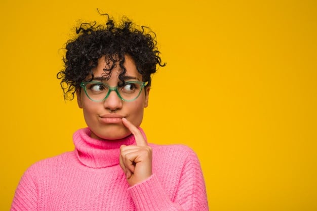 young african american woman wearing pink sweater looking sideways with doubtful skeptical expression 1187 36616