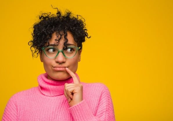 young-african-american-woman-wearing-pink-sweater-looking-sideways-with-doubtful-skeptical-expression_1187-36616